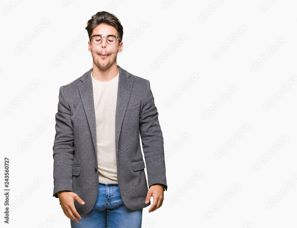 Fototapeta premium Young business man wearing glasses over isolated background making fish face with lips, crazy and comical gesture. Funny expression.
