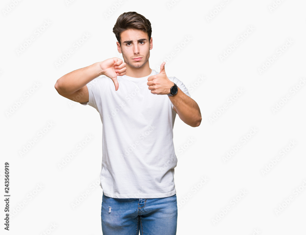 Young handsome man wearing white t-shirt over isolated background Doing thumbs up and down, disagreement and agreement expression. Crazy conflict Young handsome man wearing white t-shirt over isolated background Doing thumbs up and down, disagreement and agreement expression. Crazy conflict