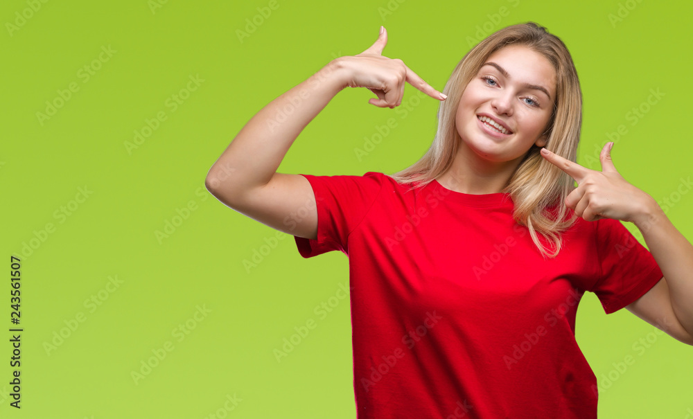 Young caucasian woman over isolated background smiling confident showing and pointing with fingers teeth and mouth. Health concept. Young caucasian woman over isolated background smiling confident showing and pointing with fingers teeth and mouth. Health concept.