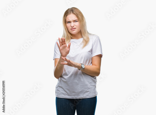 Young caucasian woman over isolated background disgusted expression, displeased and fearful doing disgust face because aversion reaction. With hands raised. Annoying concept.
