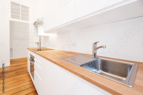 kitchen sink in new white kitchenette with wooden worktop photo