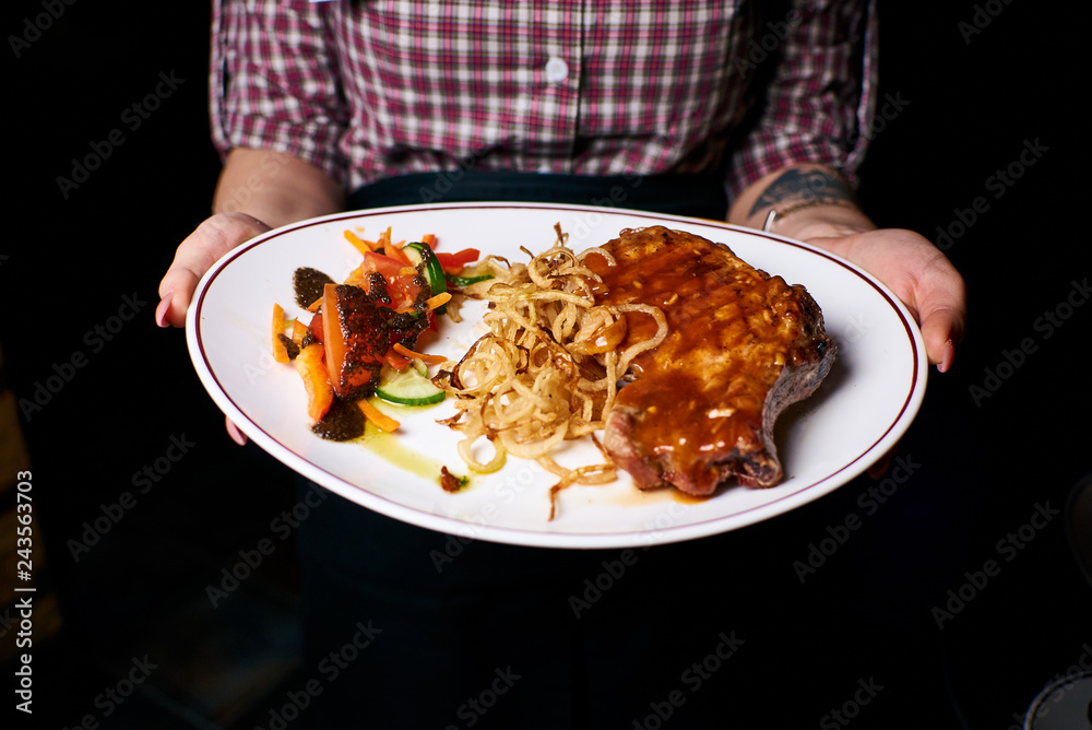 Appetizing dish on a white plate in the hands of the girl waiter, food, snack