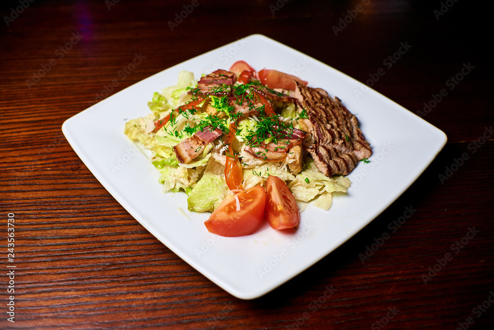 Appetizing dish on a white plate stands on a wooden table, food, snack Appetizing dish on a white plate stands on a wooden table, food, snack