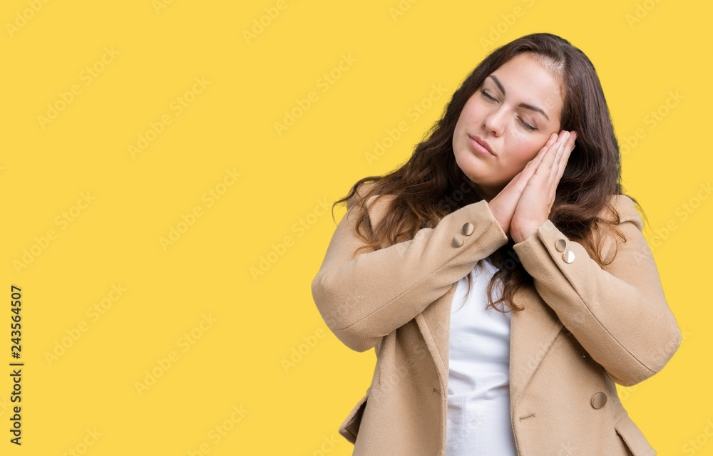 Beautiful plus size young woman wearing winter coat over isolated background sleeping tired dreaming and posing with hands together while smiling with closed eyes. Beautiful plus size young woman wearing winter coat over isolated background sleeping tired dreaming and posing with hands together while smiling with closed eyes.