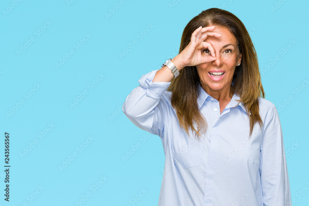 Beautiful middle age business adult woman over isolated background doing ok gesture with hand smiling, eye looking through fingers with happy face. Beautiful middle age business adult woman over isolated background doing ok gesture with hand smiling, eye looking through fingers with happy face.