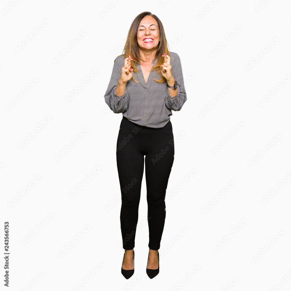 Beautiful middle age business woman smiling crossing fingers with hope and eyes closed. Luck and superstitious concept. Beautiful middle age business woman smiling crossing fingers with hope and eyes closed. Luck and superstitious concept.