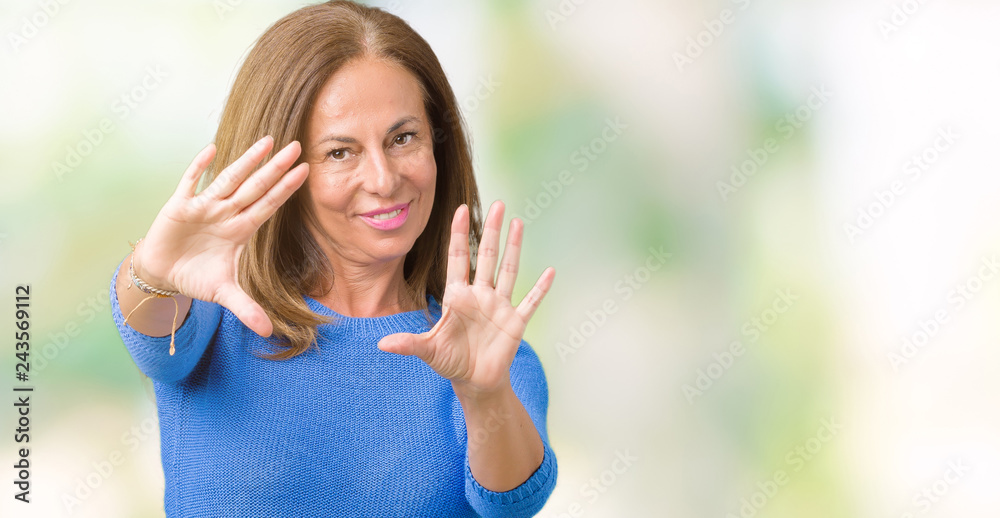 Middle age beautiful woman wearing winter sweater over isolated background Smiling doing frame using hands palms and fingers, camera perspective Middle age beautiful woman wearing winter sweater over isolated background Smiling doing frame using hands palms and fingers, camera perspective