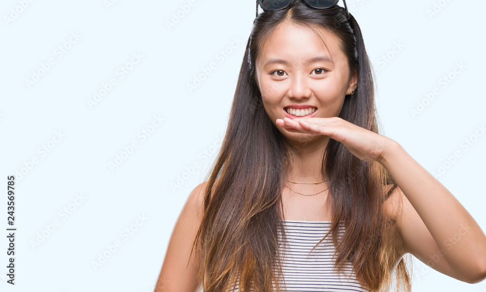 Young asian woman wearing sunglasses over isolated background gesturing with hands showing big and large size sign, measure symbol. Smiling looking at the camera. Measuring concept. Young asian woman wearing sunglasses over isolated background gesturing with hands showing big and large size sign, measure symbol. Smiling looking at the camera. Measuring concept.