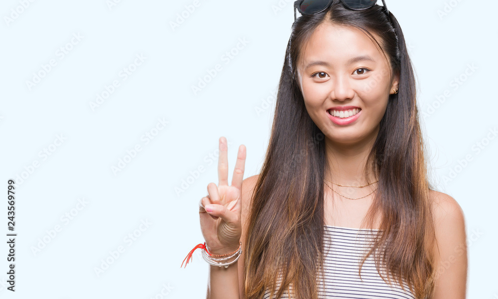 Young asian woman wearing sunglasses over isolated background showing and pointing up with fingers number two while smiling confident and happy. Young asian woman wearing sunglasses over isolated background showing and pointing up with fingers number two while smiling confident and happy.