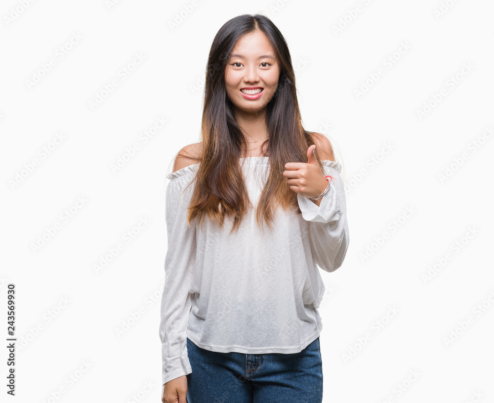 Young asian woman over isolated background doing happy thumbs up gesture with hand. Approving expression looking at the camera with showing success. Young asian woman over isolated background doing happy thumbs up gesture with hand. Approving expression looking at the camera with showing success.