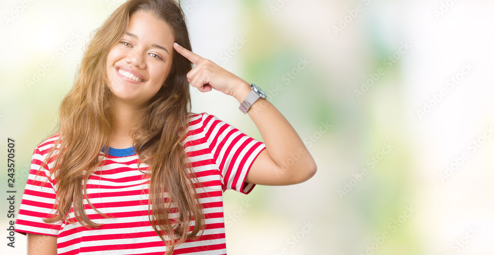 Young beautiful brunette woman wearing stripes t-shirt over isolated background Smiling pointing to head with one finger, great idea or thought, good memory