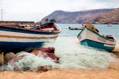 Old fishing boat on the shore. Boat with nets waiting for fishermen on the beach of Cape Verde.