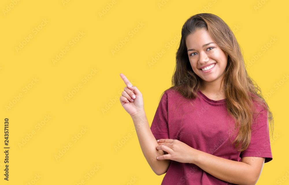 Young beautiful brunette woman over isolated background with a big smile on face, pointing with hand and finger to the side looking at the camera. Young beautiful brunette woman over isolated background with a big smile on face, pointing with hand and finger to the side looking at the camera.