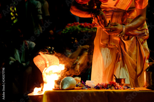 close up of young hindu priest performing daily ritual ganga aarti ceremony with fire and symbolic snake