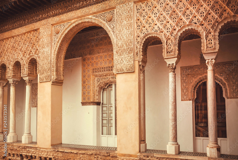 Balcony with carvings and arches inside the 14th century Alcazar royal palace, Mudejar architecture style, Seville