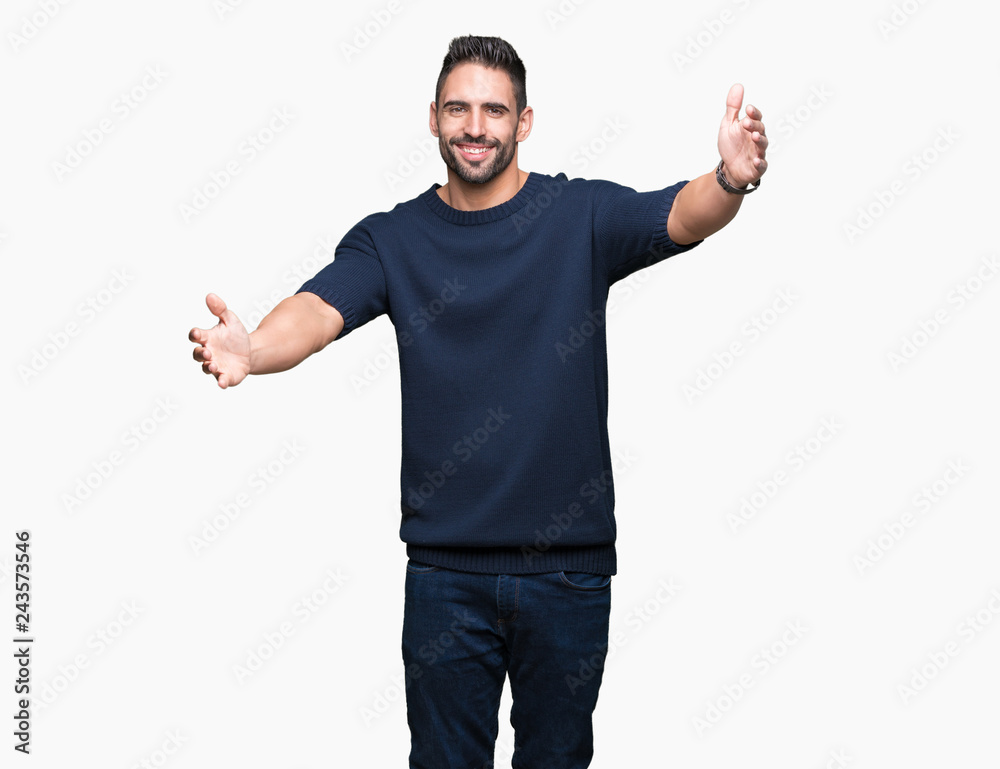 Young handsome man wearing sweater over isolated background looking at the camera smiling with open arms for hug. Cheerful expression embracing happiness. Young handsome man wearing sweater over isolated background looking at the camera smiling with open arms for hug. Cheerful expression embracing happiness.