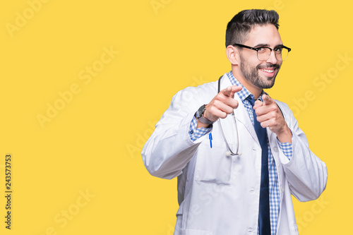 Handsome young doctor man over isolated background pointing fingers to camera with happy and funny face. Good energy and vibes.