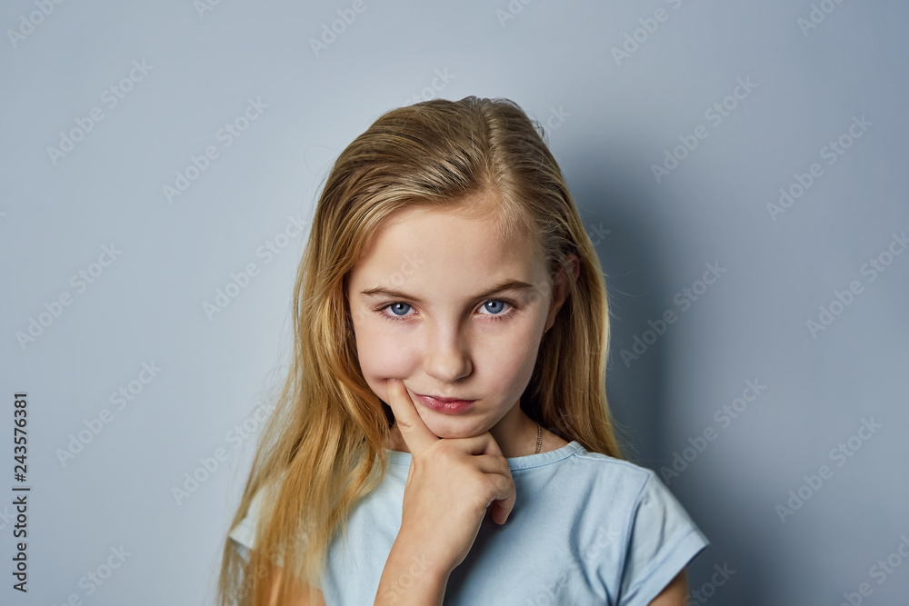 portrait of a girl, shows emotions on the face, on a blue background portrait of a girl, shows emotions on the face, on a blue background