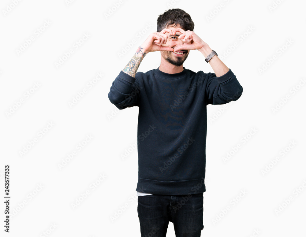 Young handsome man over isolated background Doing heart shape with hand and fingers smiling looking through sign Young handsome man over isolated background Doing heart shape with hand and fingers smiling looking through sign