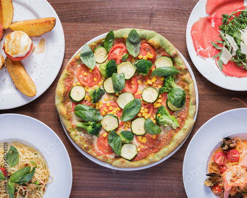 Italian Pizza, Verdura - Delicious vegetarian Pizza, beautifully arranged on a wooden table