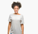 Young afro american woman over isolated background winking looking at the camera with sexy expression, cheerful and happy face.