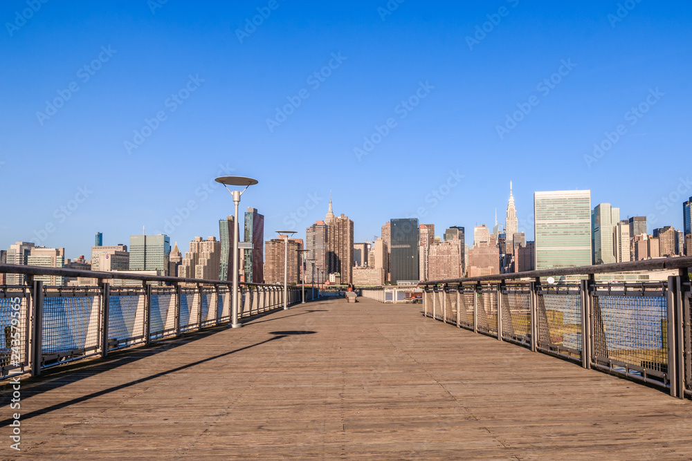 Pier in New York City - USA. Manhattan downtown skyline in the morning al view of New York City - USA. Manhattan downtown skyline and skyscrapers.
