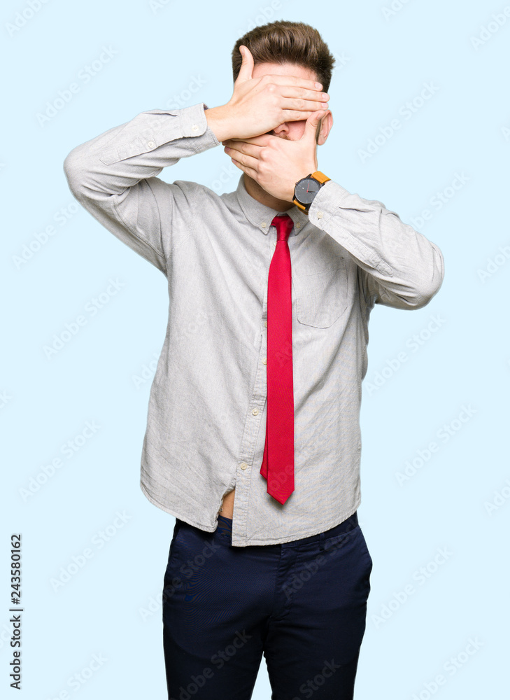 Young handsome business man Covering eyes and mouth with hands, surprised and shocked. Hiding emotion