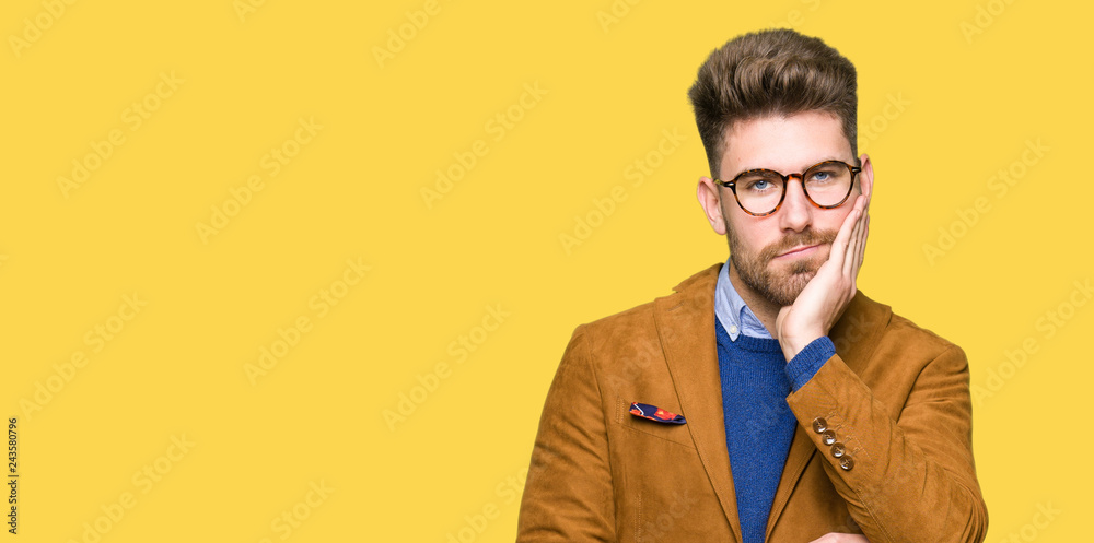 Young handsome business man wearing glasses thinking looking tired and bored with depression problems with crossed arms. Young handsome business man wearing glasses thinking looking tired and bored with depression problems with crossed arms.