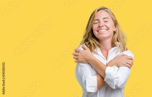 Beautiful young business woman over isolated background Hugging oneself happy and positive, smiling confident. Self love and self care photo