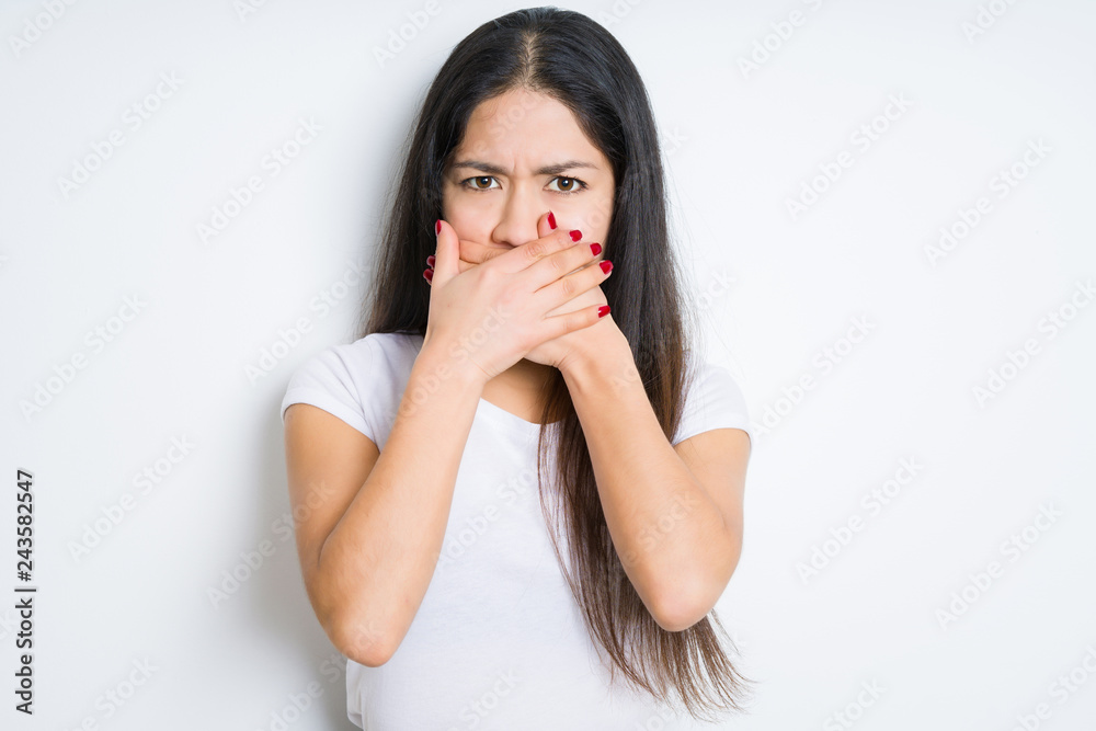 Beautiful brunette woman over isolated background shocked covering mouth with hands for mistake. Secret concept. Beautiful brunette woman over isolated background shocked covering mouth with hands for mistake. Secret concept.