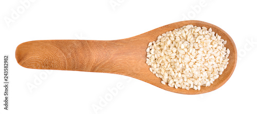 Sesame seeds on a wooden spoon as a white background.