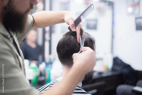 The hairdresser is doing his job. Scissor cutting.