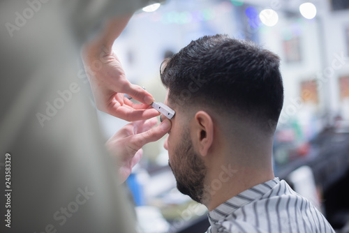 Professional hairstyle in barbershop. Men's hair care.