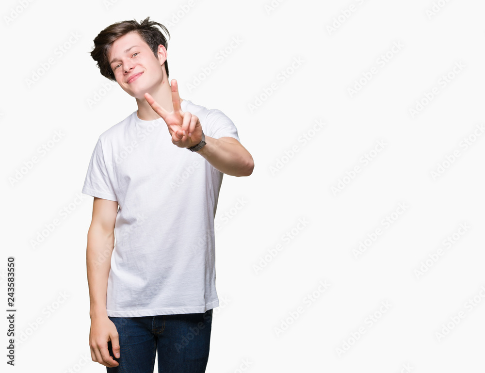 Young handsome man wearing casual white t-shirt over isolated background smiling looking to the camera showing fingers doing victory sign. Number two. Young handsome man wearing casual white t-shirt over isolated background smiling looking to the camera showing fingers doing victory sign. Number two.