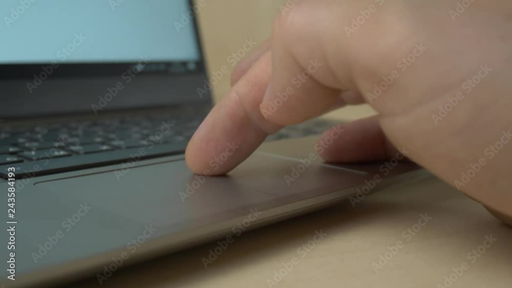 Hand working on laptop touchpad Hand working on laptop touchpad