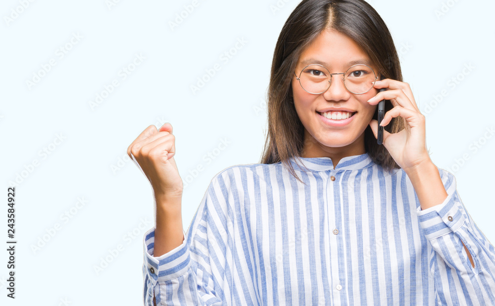 Young asian woman speaking on the phone over isolated background screaming proud and celebrating victory and success very excited, cheering emotion Young asian woman speaking on the phone over isolated background screaming proud and celebrating victory and success very excited, cheering emotion
