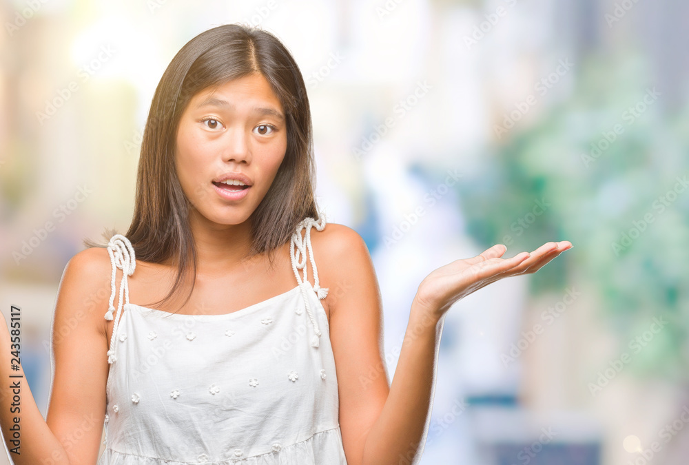 Young asian woman over isolated background clueless and confused expression with arms and hands raised. Doubt concept. Young asian woman over isolated background clueless and confused expression with arms and hands raised. Doubt concept.