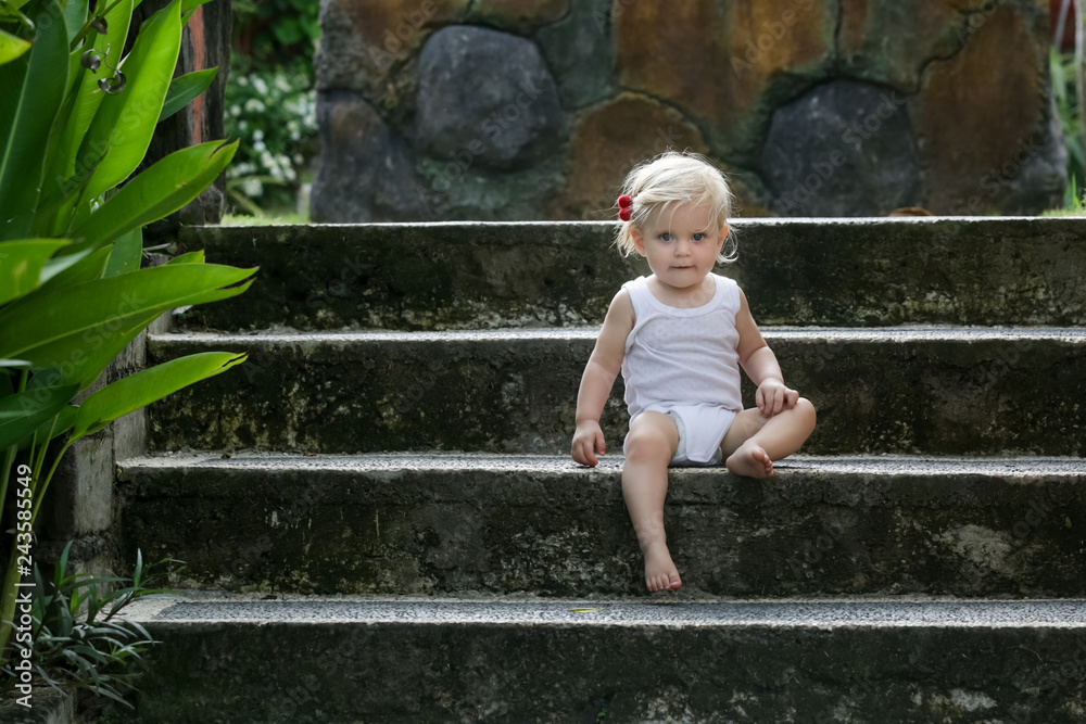 Outdoor portrait of a cute baby girl sitting on the stairs Outdoor portrait of a cute baby girl sitting on the stairs