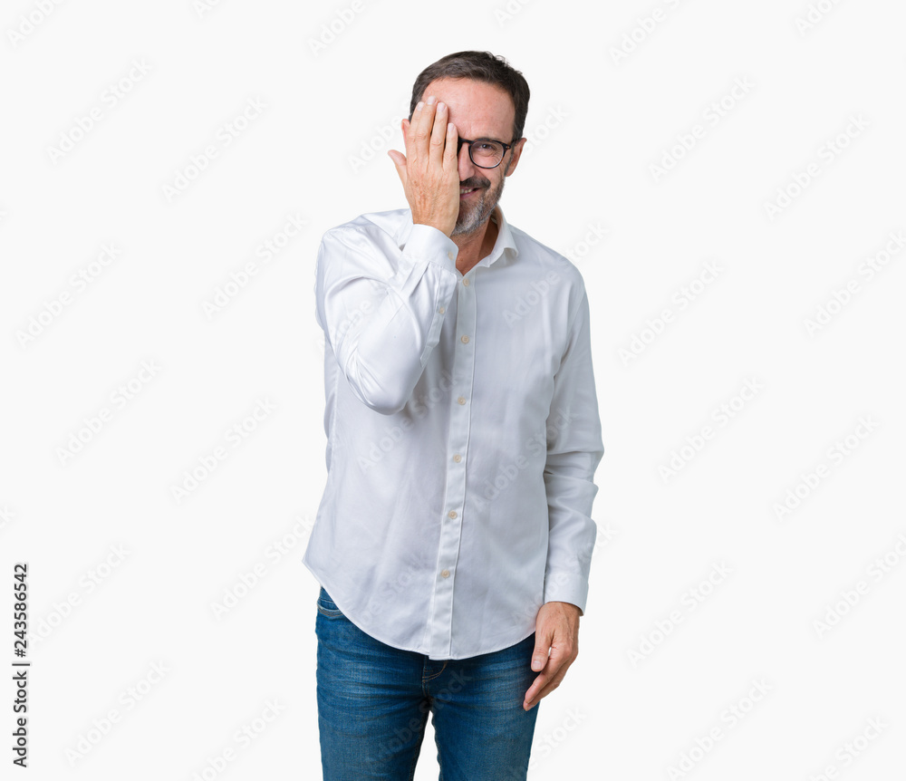 Handsome middle age elegant senior business man wearing glasses over isolated background covering one eye with hand with confident smile on face and surprise emotion.