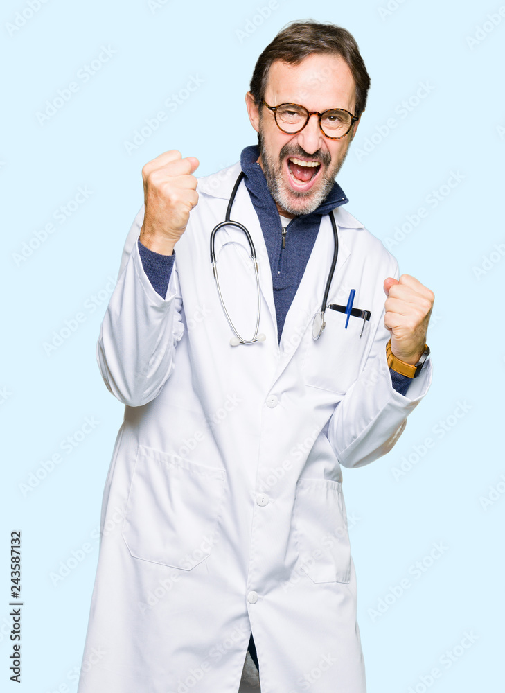 Handsome middle age doctor man wearing medical coat very happy and excited doing winner gesture with arms raised, smiling and screaming for success. Celebration concept. Handsome middle age doctor man wearing medical coat very happy and excited doing winner gesture with arms raised, smiling and screaming for success. Celebration concept.