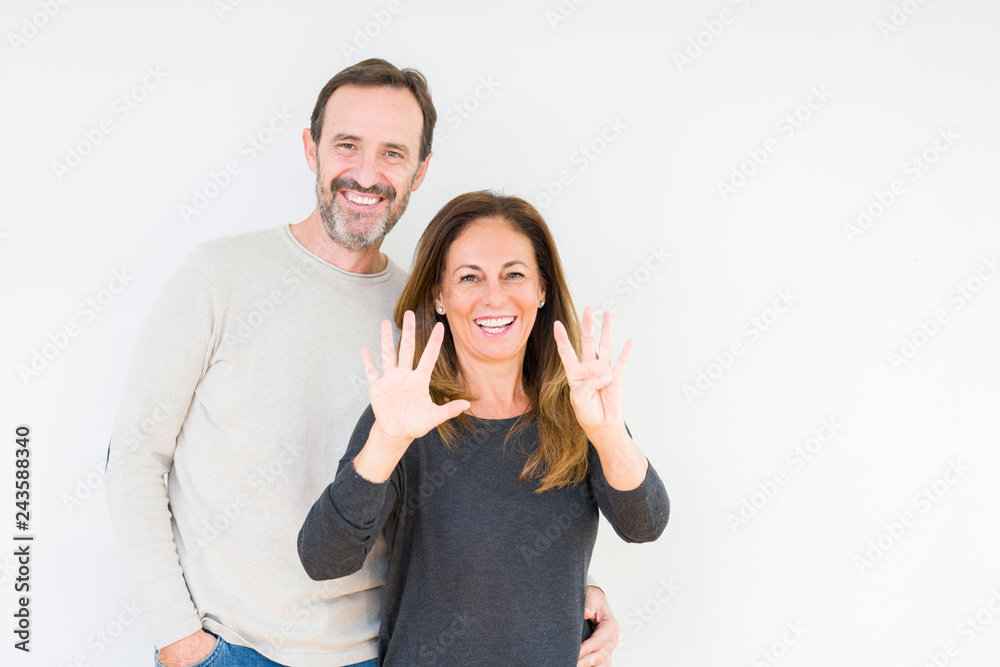 Beautiful middle age couple in love over isolated background showing and pointing up with fingers number nine while smiling confident and happy. Beautiful middle age couple in love over isolated background showing and pointing up with fingers number nine while smiling confident and happy.