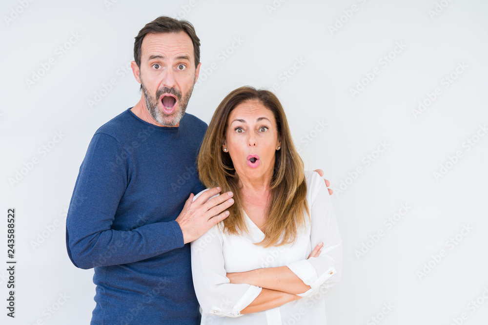 Beautiful middle age couple in love over isolated background afraid and shocked with surprise expression, fear and excited face. Beautiful middle age couple in love over isolated background afraid and shocked with surprise expression, fear and excited face.