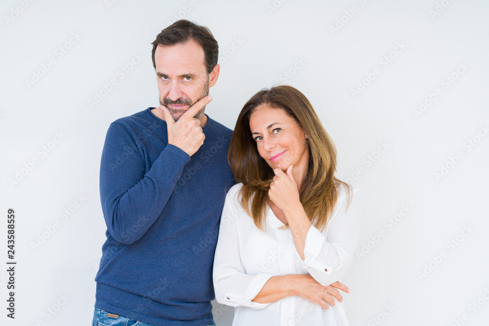 Beautiful middle age couple in love over isolated background looking confident at the camera with smile with crossed arms and hand raised on chin. Thinking positive. Beautiful middle age couple in love over isolated background looking confident at the camera with smile with crossed arms and hand raised on chin. Thinking positive.