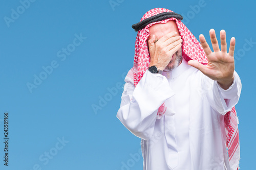 Senior arab man wearing keffiyeh over isolated background covering eyes with hands and doing stop gesture with sad and fear expression. Embarrassed and negative concept.