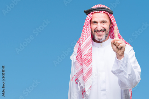 Tablou canvas Senior arab man wearing keffiyeh over isolated background showing and pointing up with finger number one while smiling confident and happy