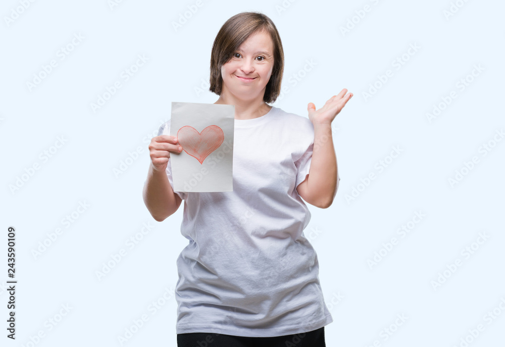 Young adult woman with down syndrome holding red heart card over isolated background very happy and excited, winner expression celebrating victory screaming with big smile and raised hands Young adult woman with down syndrome holding red heart card over isolated background very happy and excited, winner expression celebrating victory screaming with big smile and raised hands