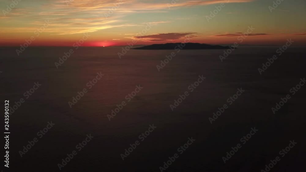 Aerial Orange Sunset above the sea with the Giglio Island in background. Aerial Orange Sunset above the sea with the Giglio Island in background.