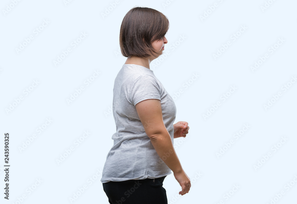 Young adult woman with down syndrome over isolated background looking to side, relax profile pose with natural face with confident smile. Young adult woman with down syndrome over isolated background looking to side, relax profile pose with natural face with confident smile.