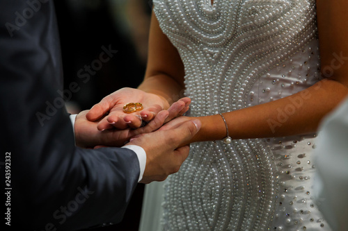 Par de alianças colocadas em cima da mão dos noivos no dia do casamento para serem abençoadas na cerimônia