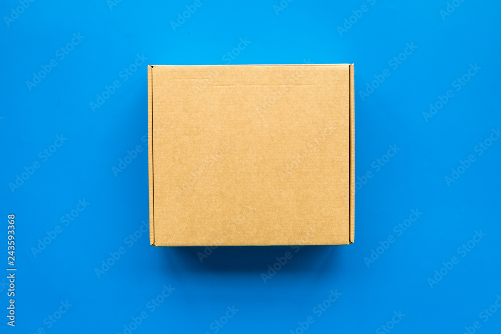 Delivery concept. Cardboard box on blue background top view copy space Delivery concept. Cardboard box on blue background top view copy space